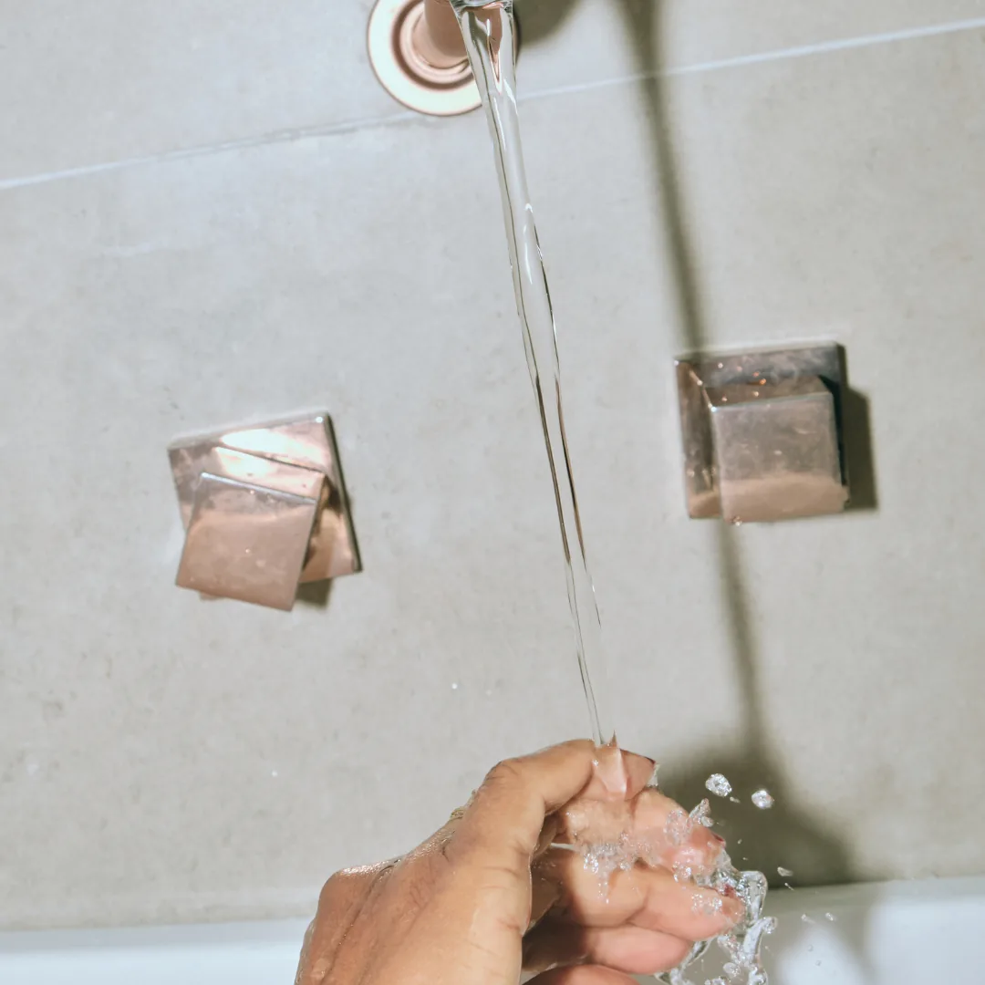 washing hands under salt free water faucet