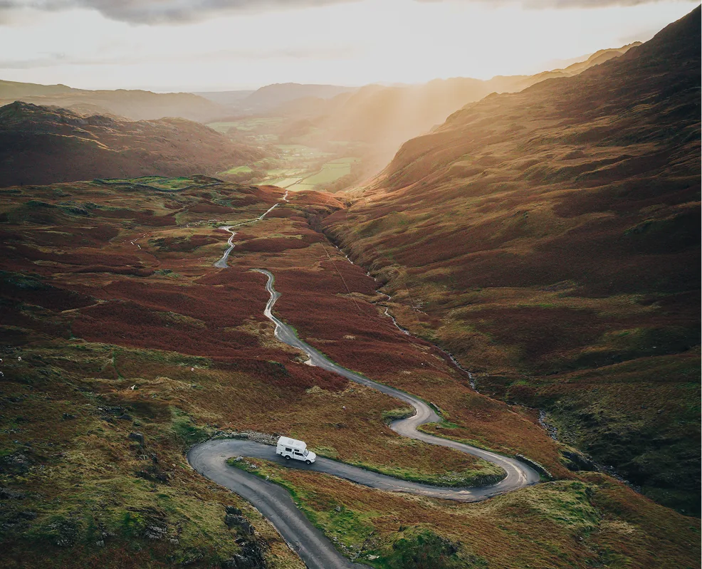 travel van driving down windy road in the mountains