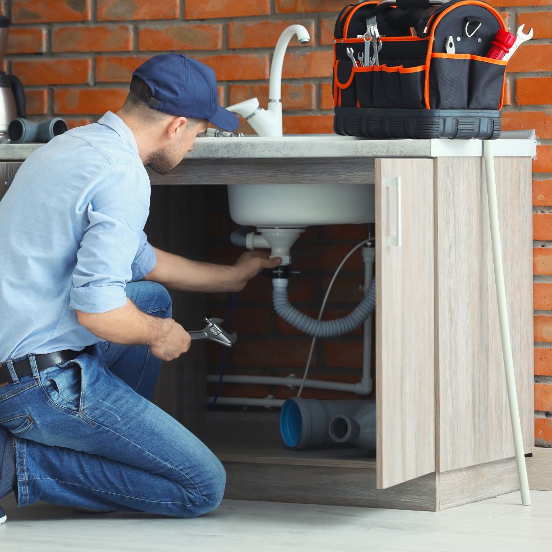 plumber working on drain under sink plumber working on drain under sink