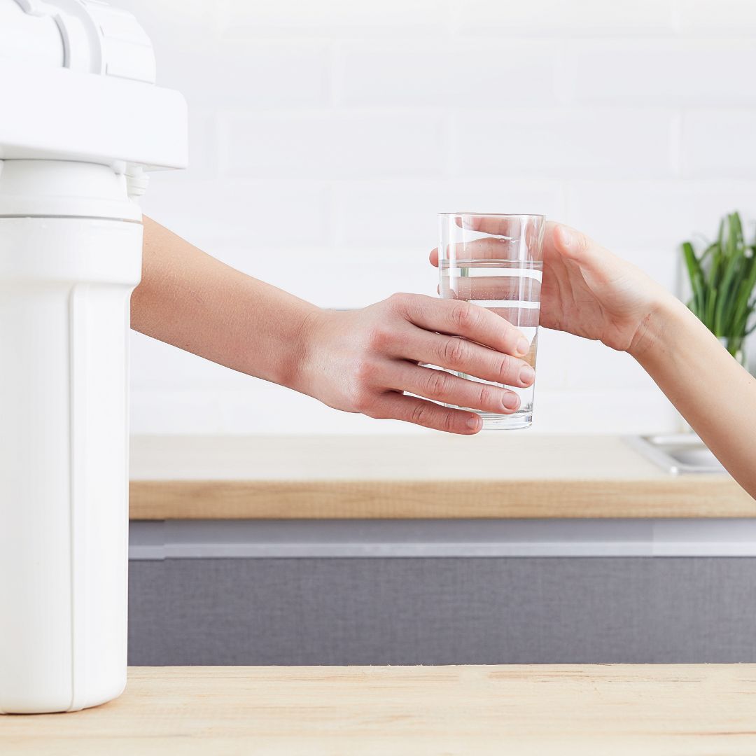 person handing clear glass of water to another person person handing clear glass of water to another person
