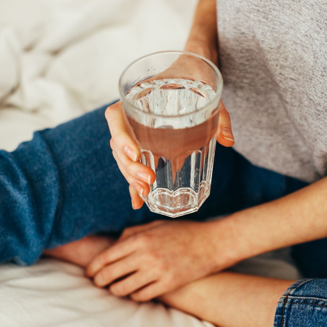person holding a glass of water person holding a glass of water